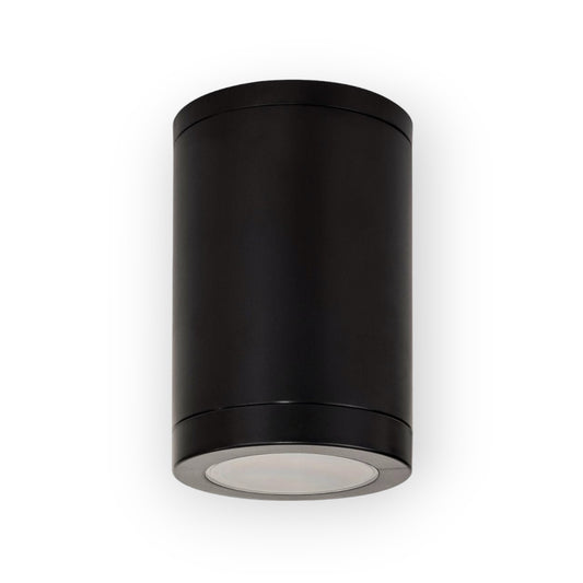 The image illustrates the Canon Surface Mount Light in black, featuring a cylindrical design with a matte finish. Its downward-facing light is shielded by a clear diffuser, providing targeted illumination ideal for both indoor and outdoor settings.