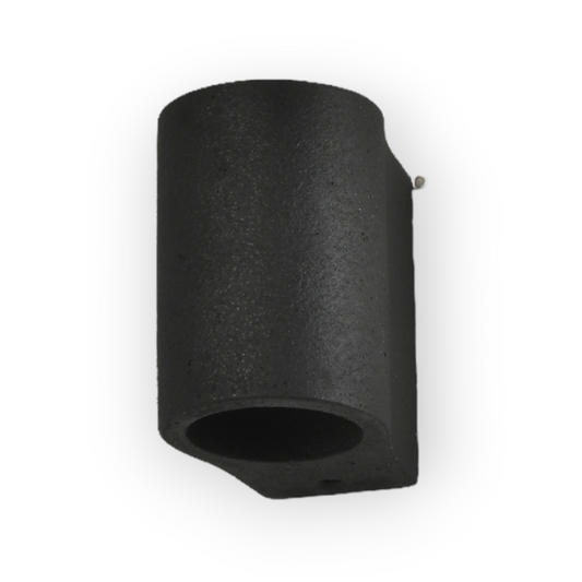 The image features the Cato Wall Light, a cylindrical fixture with a textured stone-like finish that provides both uplight and downlight to create a soft, ambient effect. This wall-mounted light is ideal for adding a modern yet earthy touch to any space.