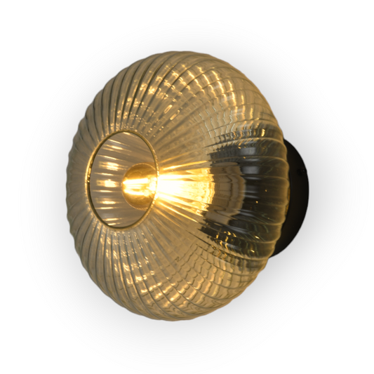 This image features the Hera Wall Light, a captivating lighting fixture with a ribbed glass sphere that enhances the light's reflection, creating a stunning interplay of light and shadow. The golden interior amplifies its glow, making it a focal point in any room.