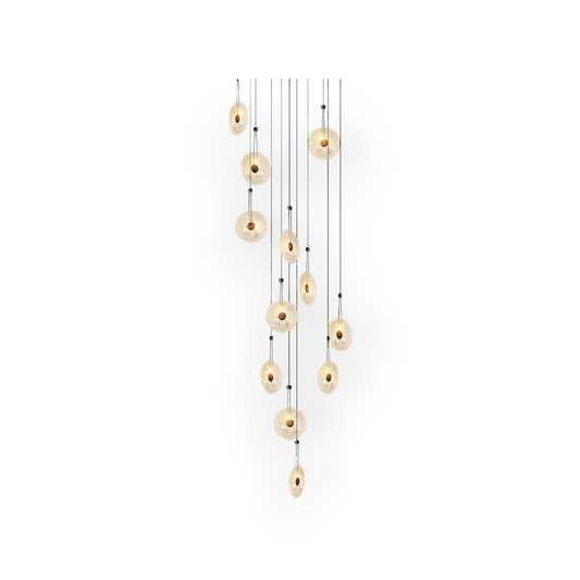 This image features the Maris 12L Chandelier, a dazzling constellation of lights with twelve textured glass discs that are suspended at varying heights. The golden hues and the gentle diffusion of light through each disc create an ethereal ambiance.