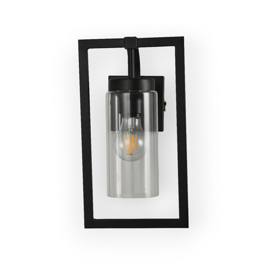 The image shows the Porter Wall Light, featuring a matte black frame that elegantly outlines a clear glass shade, revealing a vintage-style filament bulb. This design merges industrial elements with a modern aesthetic.