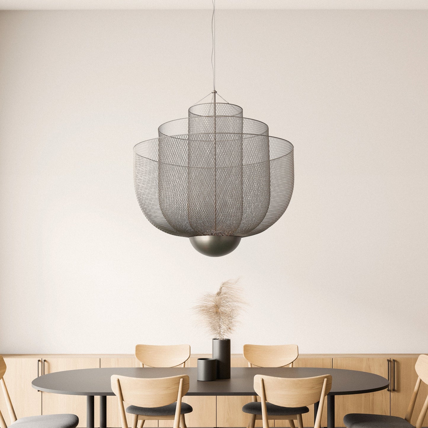 This image showcases the Soleil Large Chandelier, an exquisite fixture featuring layered mesh screens made from carbon steel. The metallic finish gleams with a subtle sheen, enhancing the light's diffusion for a soft, atmospheric effect.